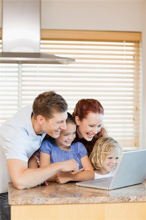 simsearch:400-05751173,k - Family exploring the internet in the kitchen together Stock Photo - Budget Royalty-Free & Subscription, Code: 400-05751184