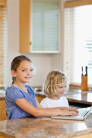 simsearch:400-05751173,k - Brother and sister together with laptop in the kitchen Stock Photo - Budget Royalty-Free & Subscription, Code: 400-05751181