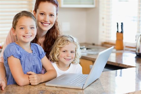 simsearch:400-05751173,k - Mother together with children on the laptop in the kitchen Stock Photo - Budget Royalty-Free & Subscription, Code: 400-05751182