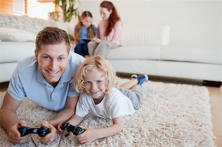 Father and son on the floor playing video games together Stock Photo - Budget Royalty-Free & Subscription, Code: 400-05751525