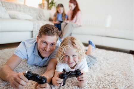 simsearch:400-05751526,k - Father and son in the living room playing video games together Stock Photo - Budget Royalty-Free & Subscription, Code: 400-05751526