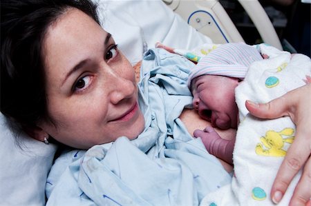 Beautiful new mother happy holding her infant baby after giving birth in hospital. Stock Photo - Budget Royalty-Free & Subscription, Code: 400-05752817