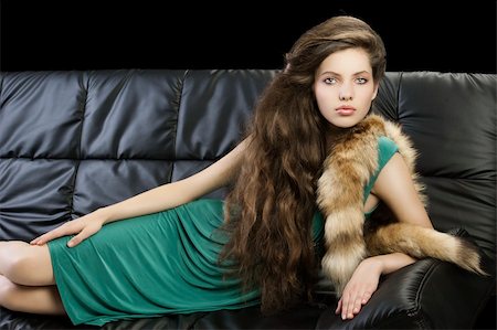 sophisticated elegant woman laying on a black sofa with hair style and wearing a green dress and a tail fur looking in camera Stock Photo - Budget Royalty-Free & Subscription, Code: 400-05753441