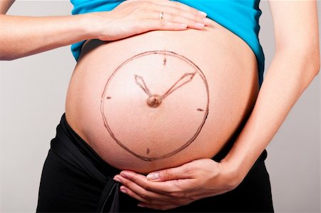 simsearch:400-04866555,k - clock. Pregnant woman on gray background with painted watch Foto de stock - Super Valor sin royalties y Suscripción, Código: 400-05875634