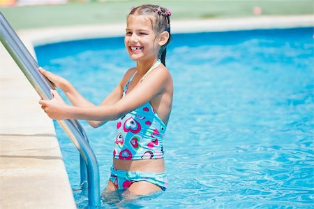 Pretty young girl stay at pool's edge Stock Photo - Budget Royalty-Free & Subscription, Code: 400-05875926