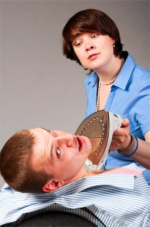 business woman is torturing her associate with electric iron. Focus on woman. Stock Photo - Budget Royalty-Free & Subscription, Code: 400-05876060