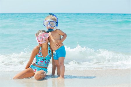 Smiling Happy brother and sister posing on a beach wearing snorkeling equipment. In the background the sea Stock Photo - Budget Royalty-Free & Subscription, Code: 400-05877572