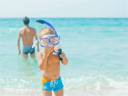 father and son in the bath - Cute little boy with snorkeling equipment on tropical beach, his father background. Stock Photo - Budget Royalty-Free & Subscription, Code: 400-05877665