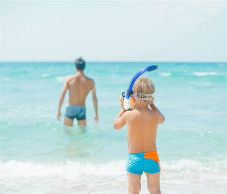 father son bath - Cute little boy with snorkeling equipment on tropical beach, his father background. Foto de stock - Super Valor sin royalties y Suscripción, Código: 400-05877932