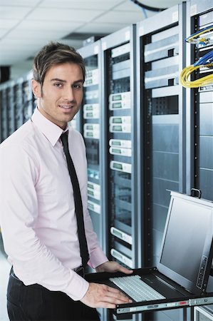 simsearch:400-05881495,k - young engeneer business man with thin modern aluminium laptop in network server room Stock Photo - Budget Royalty-Free & Subscription, Code: 400-05878616