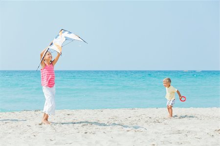 pictures of boy fly kites in the sky - Young cute girl playing her brother with a colorful kite on the tropical beach. Stock Photo - Budget Royalty-Free & Subscription, Code: 400-05879036