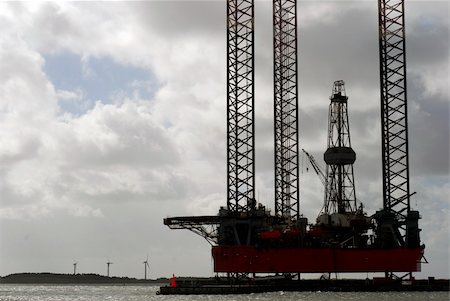 Closeup of ocean oil rig docked in Esbjerg harbor. Danish island Fanoe with windmills can be seen in the background. Foto de stock - Super Valor sin royalties y Suscripción, Código: 400-05886834