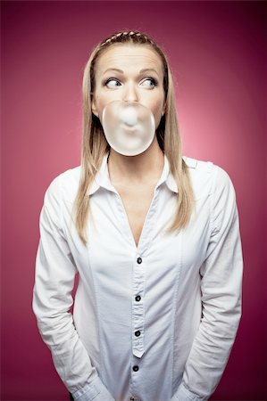 Young woman making a chewing gum bubble and looking right Stock Photo - Budget Royalty-Free & Subscription, Code: 400-05881477