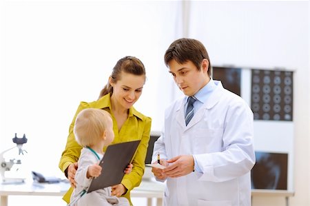 Pediatrician doctor explaining something to mother while baby playing on table Stock Photo - Budget Royalty-Free & Subscription, Code: 400-05894316