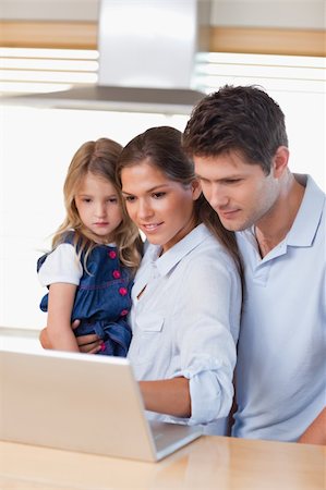 simsearch:400-05751173,k - Portrait of a family using a laptop in their kitchen Stock Photo - Budget Royalty-Free & Subscription, Code: 400-05894665