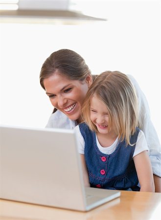 simsearch:400-05751173,k - Portrait of a mother and her daughter using a notebook in their kitchen Stock Photo - Budget Royalty-Free & Subscription, Code: 400-05894685