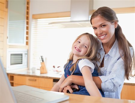 simsearch:400-05751173,k - Happy mother and her daughter using a laptop in their kitchen Stock Photo - Budget Royalty-Free & Subscription, Code: 400-05894688
