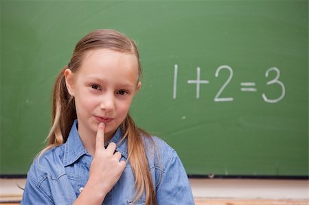 simsearch:625-01250891,k - Smiling schoolgirl thinking in front of a blackboard Stock Photo - Budget Royalty-Free & Subscription, Code: 400-05894745