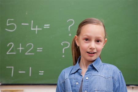 simsearch:625-01250891,k - Smiling schoolgirl posing in front of a blackboard Stock Photo - Budget Royalty-Free & Subscription, Code: 400-05894751