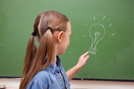 simsearch:400-05896424,k - Schoolgirl pointing at a bulb on a blackboard Stock Photo - Budget Royalty-Free & Subscription, Code: 400-05894752