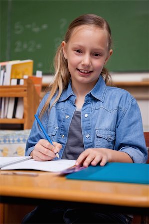 simsearch:400-05896357,k - Portrait of a smiling schoolgirl writing in a classroom Stock Photo - Budget Royalty-Free & Subscription, Code: 400-05895035