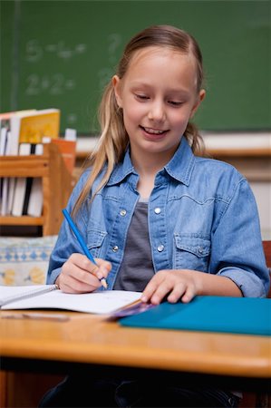 simsearch:400-05896357,k - Portrait of a happy schoolgirl writing in a classroom Stock Photo - Budget Royalty-Free & Subscription, Code: 400-05895036