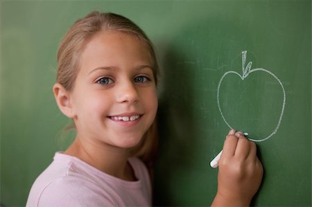 simsearch:400-05896424,k - Smiling schoolgirl drawing an apple on a blackboard Stock Photo - Budget Royalty-Free & Subscription, Code: 400-05895048