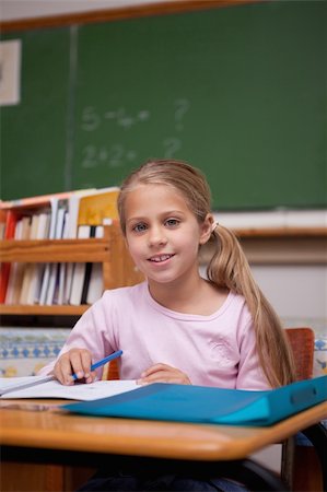 simsearch:400-05896357,k - Portrait of a cute schoolgirl writing in a classroom Stock Photo - Budget Royalty-Free & Subscription, Code: 400-05895040