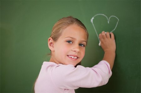 simsearch:400-05896424,k - Smiling schoolgirl drawing a heart on a blackboard Stock Photo - Budget Royalty-Free & Subscription, Code: 400-05895050
