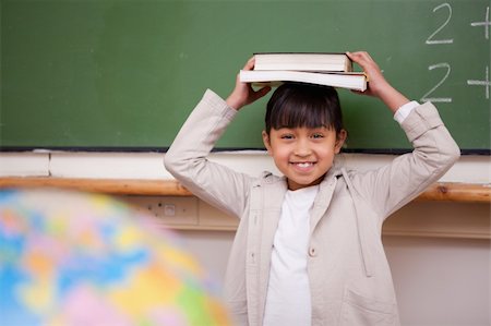 simsearch:400-05896424,k - Schoolgirl holding her book on her head in a classroom Stock Photo - Budget Royalty-Free & Subscription, Code: 400-05895076
