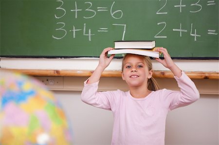 simsearch:400-05896424,k - Smiling schoolgirl holding her book on her head in a classroom Stock Photo - Budget Royalty-Free & Subscription, Code: 400-05895077