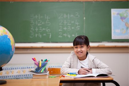 Smiling schoolgirl drawing on a coloring book in a classroom Stock Photo - Budget Royalty-Free & Subscription, Code: 400-05895089