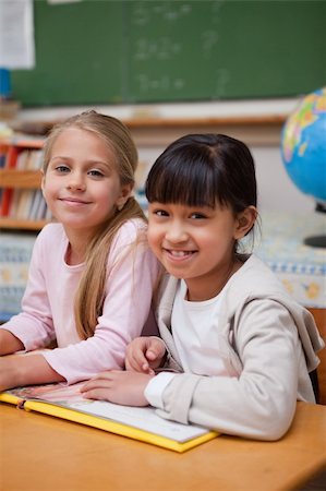 simsearch:400-05896357,k - Portrait of smiling schoolgirls reading a fairy tale in a classroom Stock Photo - Budget Royalty-Free & Subscription, Code: 400-05895098