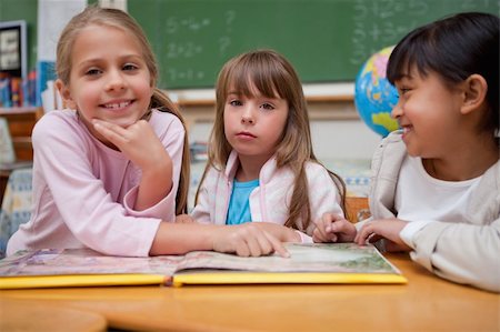 simsearch:400-05896357,k - Schoolgirls reading a fairy tale to their classmate in a classroom Stock Photo - Budget Royalty-Free & Subscription, Code: 400-05895099