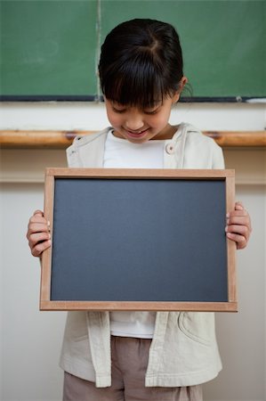 simsearch:400-05896424,k - Portrait of a cute girl holding a school slate in a classroom Stock Photo - Budget Royalty-Free & Subscription, Code: 400-05895115