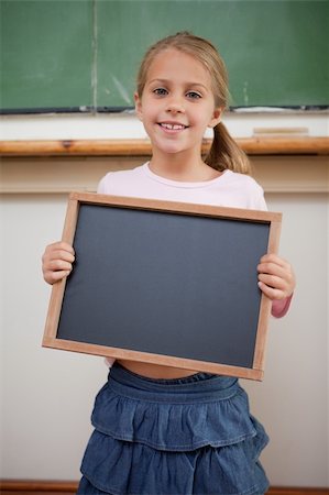 simsearch:400-05896424,k - Portrait of a happy girl holding at a school slate in a classroom Stock Photo - Budget Royalty-Free & Subscription, Code: 400-05895119