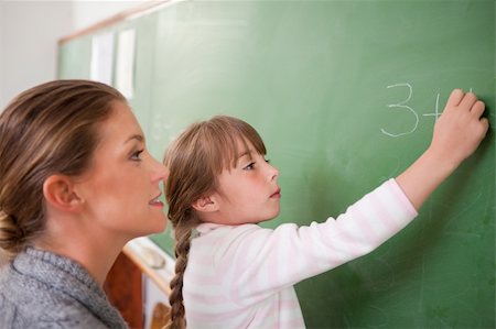Teacher and a pupil making an addition on a blackboard Stock Photo - Budget Royalty-Free & Subscription, Code: 400-05895164