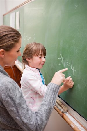 Portrait of a teacher and a pupil making an addition on a blackboard Stock Photo - Budget Royalty-Free & Subscription, Code: 400-05895165