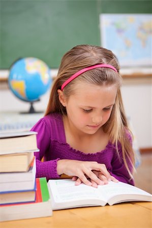 simsearch:400-05896357,k - Portrait of schoolgirl reading a book in a classroom Stock Photo - Budget Royalty-Free & Subscription, Code: 400-05895416