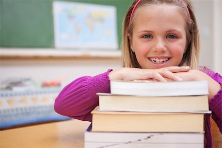 simsearch:400-05896424,k - Schoolgirl posing with a stack of books in a classroom Stock Photo - Budget Royalty-Free & Subscription, Code: 400-05895426
