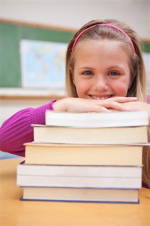 simsearch:400-05896357,k - Portrait of a smiling schoolgirl posing with a stack of books in a classroom Stock Photo - Budget Royalty-Free & Subscription, Code: 400-05895427