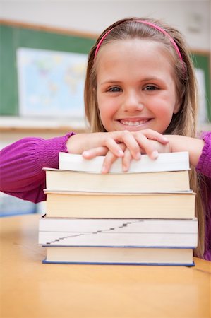 simsearch:400-05896424,k - Portrait of a happy schoolgirl posing with a stack of books in a classroom Stock Photo - Budget Royalty-Free & Subscription, Code: 400-05895428