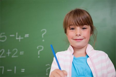 simsearch:400-05896357,k - Cute girl holding a pen in front of a blackboard Stock Photo - Budget Royalty-Free & Subscription, Code: 400-05895496
