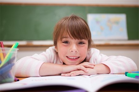 Happy schoolgirl leaning on a desk in classroom Stock Photo - Budget Royalty-Free & Subscription, Code: 400-05895491