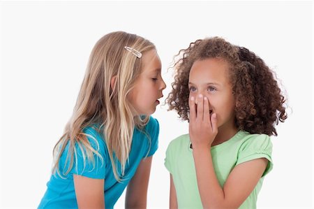 pictures of a little girl whispering - Girl whispering a secret to her friend against a white background Stock Photo - Budget Royalty-Free & Subscription, Code: 400-05895576