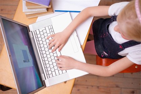 Above view of a girl using a notebook in a classroom Stock Photo - Budget Royalty-Free & Subscription, Code: 400-05896334