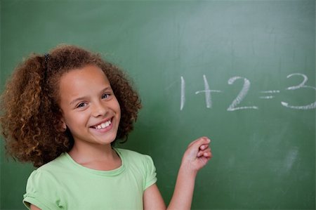 simsearch:625-01250891,k - Cute schoolgirl pointing at an addition on a blackboard Stock Photo - Budget Royalty-Free & Subscription, Code: 400-05896399