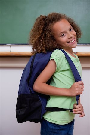 simsearch:400-05896424,k - Portrait of a schoolgirl showing her backpack in a classroom Stock Photo - Budget Royalty-Free & Subscription, Code: 400-05896423