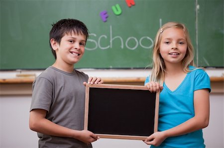 pupil in a empty classroom - Pupils holding a school slate in a classroom Stock Photo - Budget Royalty-Free & Subscription, Code: 400-05896517