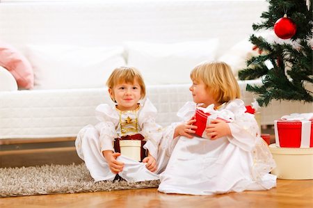simsearch:400-05899085,k - Two cute twins girl sitting with presents boxes near Christmas tree Foto de stock - Super Valor sin royalties y Suscripción, Código: 400-05896829